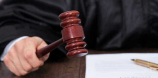 Judges hand holding gavel next to documents
