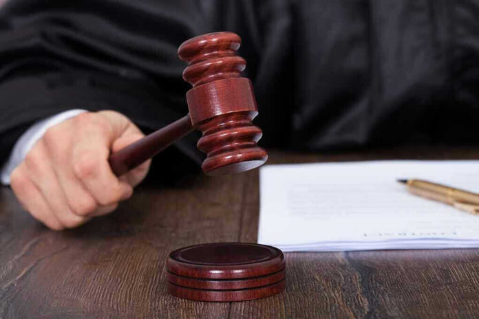 Judges hand holding gavel next to documents
