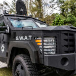 VIDEO: SWAT Teams Storm Hideout — Final Fugitive DOWN Armored SWAT vehicle parked in a grassy area