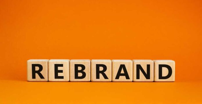 shutterstock_2168301733.jpg Wooden blocks spelling the word REBRAND on an orange background