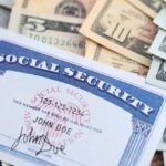 Social Security Recipients Get DOUBLE Hit A social security card placed on top of various denominations of US currency