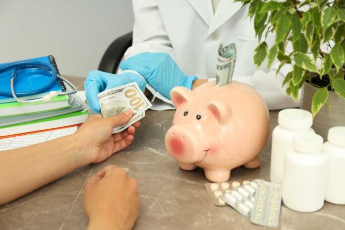 shutterstock_2508658517.jpg A patient handing cash to a healthcare professional in a medical setting