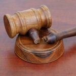 A wooden gavel resting on a circular base