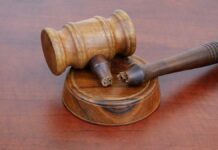 A wooden gavel resting on a circular base