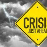 Crisis EXPLODES — Trump Takes Action Yellow sign reading Crisis Just Ahead with stormy sky