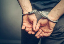 Huge Theft SHOCKS — More Arrests! Person with handcuffs behind their back.