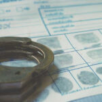 Handcuffs on a fingerprint document.