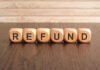 Wooden blocks spelling refund on table