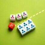 Colorful dice representing business roles and a scissors icon on a green background