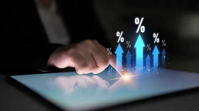 A hand touching a tablet screen with upward arrows and percentage symbols