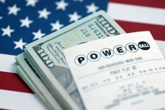 Powerball lottery ticket placed on a stack of cash with an American flag background
