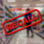 Recall stamp on blurred store aisle background.