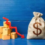 A stack of cardboard boxes with a downward trend arrow and a money bag