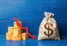 Trade Deficit DOUBLES — Did Tariffs Backfire? A stack of cardboard boxes with a downward trend arrow and a money bag