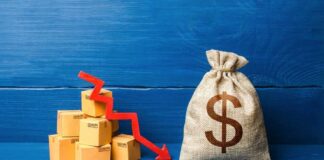 A stack of cardboard boxes with a downward trend arrow and a money bag