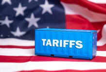 Trump’s New 100% Tariff Bombshell Shipping container reading tariffs on the American flag