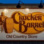 Cracker Barrel restaurant sign featuring a seated figure and a barrel