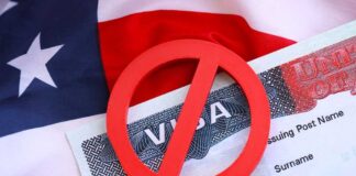 A red 'no' symbol over a visa document on an American flag background