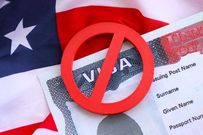 A red 'no' symbol over a visa document on an American flag background