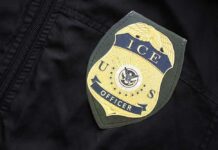 Close-up of an ICE officer badge on a black jacket