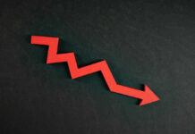 Rates Drop to 3-Year Low — Stunning Reversal Red zigzag arrow pointing down on dark background.