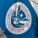 U.S. Department of Homeland Security flag on building.