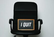 An office chair with a framed sign that says 'I QUIT'