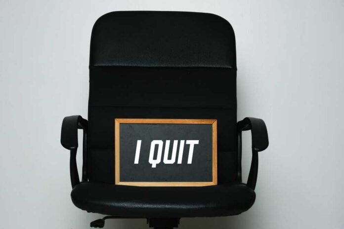 An office chair with a framed sign that says 'I QUIT'