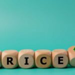 Wooden blocks spelling 'PRICE' with arrows indicating increase and decrease