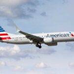 American Airlines airplane approaching for landing against a cloudy sky