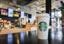 Starbucks’ DIRTY Secret: Maggots in Milk Dispenser? Coffee cup on table in cafe interior