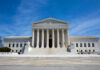 U.S. Supreme Court building under clear blue sky.