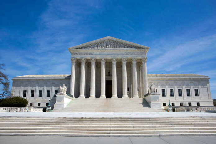 U.S. Supreme Court building under clear blue sky.