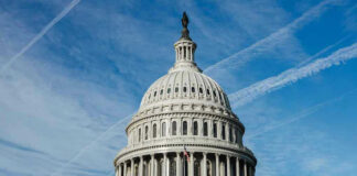 U.S. Capitol building dome against blue sky.