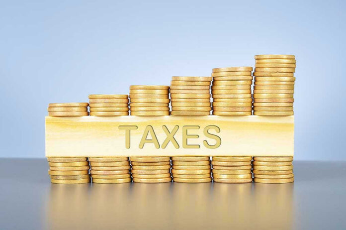Stacked coins with TAXES on block beneath.