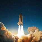 Space shuttle launching into a starry night sky.