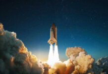 Space shuttle launching into a starry night sky.