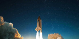 Space shuttle launching into a starry night sky.