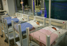 Newborn Brain Hemorrhages SURGE Five sleeping newborns in hospital bassinets.