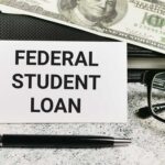 A sign reading 'Federal Student Loan' next to a stack of money and a pen