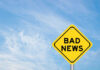 Yellow sign reads bad news in sky