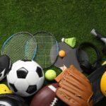 Variety of sports equipment arranged on green grass