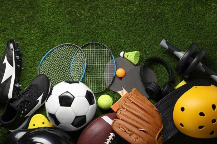 Variety of sports equipment arranged on green grass