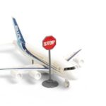 A toy airplane next to a stop sign