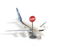 A toy airplane next to a stop sign