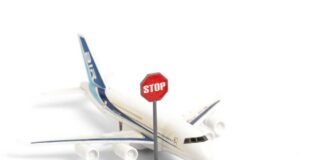 A toy airplane next to a stop sign