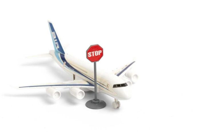 A toy airplane next to a stop sign