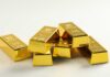 A stack of shiny gold bars arranged on a light background