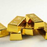 A stack of shiny gold bars arranged on a light background