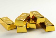 A stack of shiny gold bars arranged on a light background